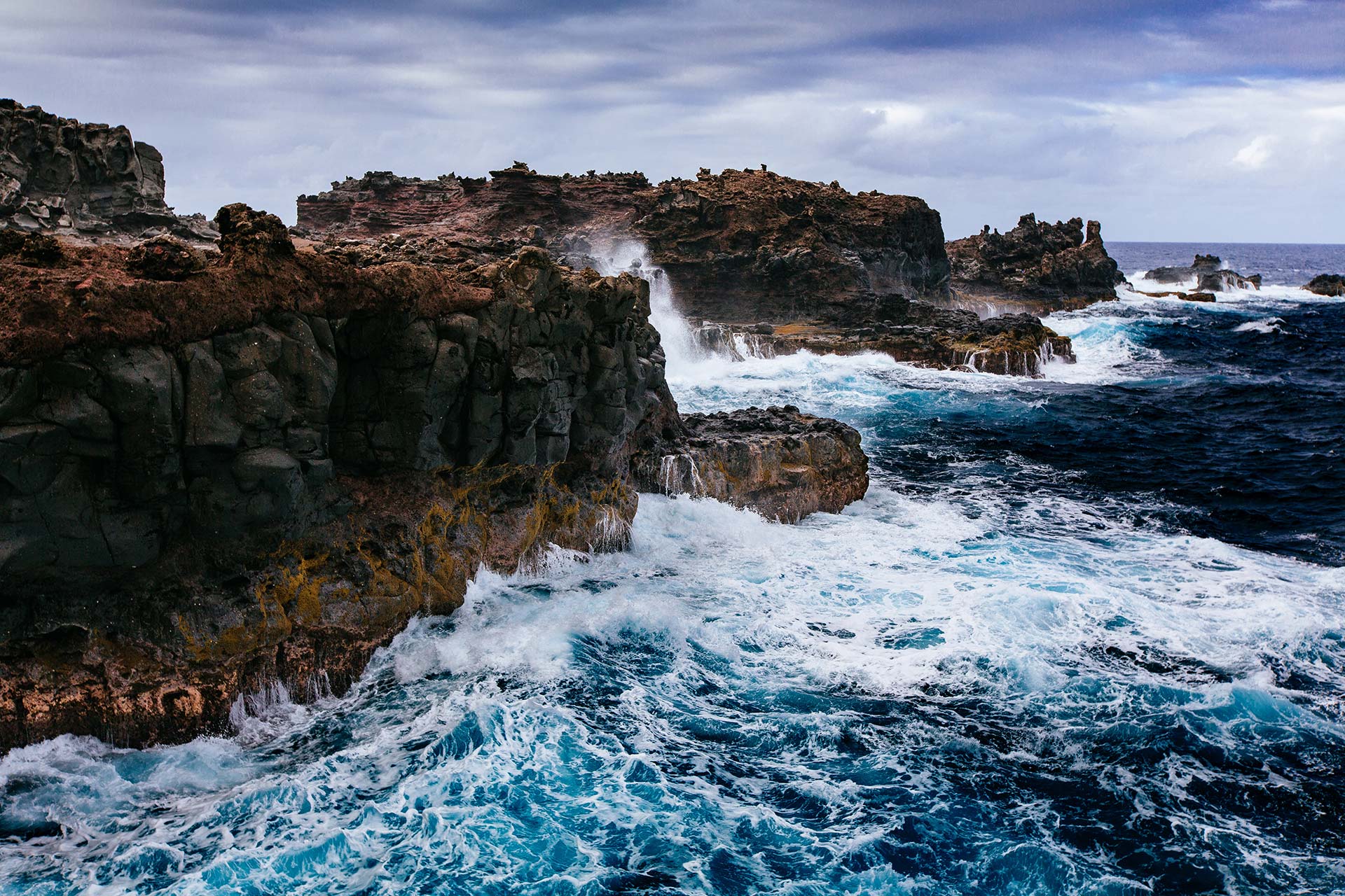 A body of water with waves crashing on the rocks.