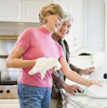 Two people are washing dishes in a kitchen.
