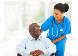 A nurse is helping an elderly man in a wheelchair.