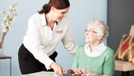A woman is helping an older person eat.