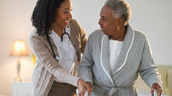 A woman and an older person holding hands.