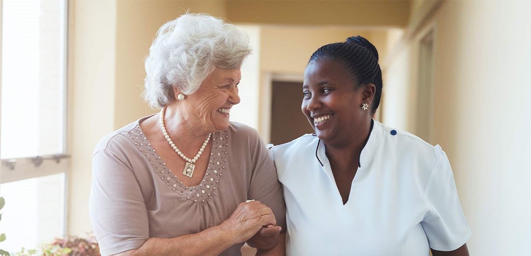 Two ladies talking with each other and smiling