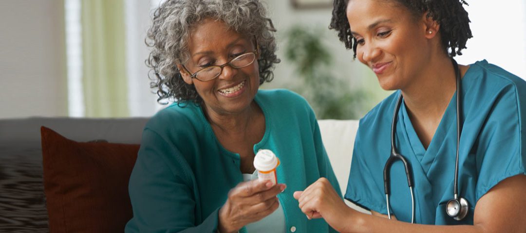 A woman holding a pill bottle next to another person.