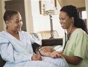 A nurse and patient in a room with a couch.
