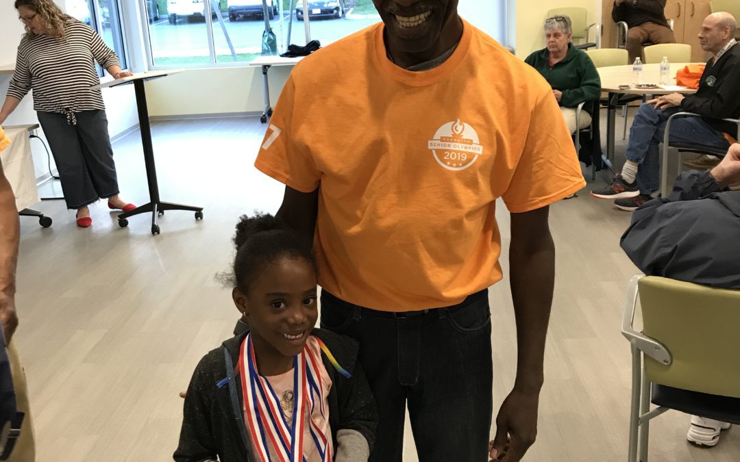 An old man standing with a small girl