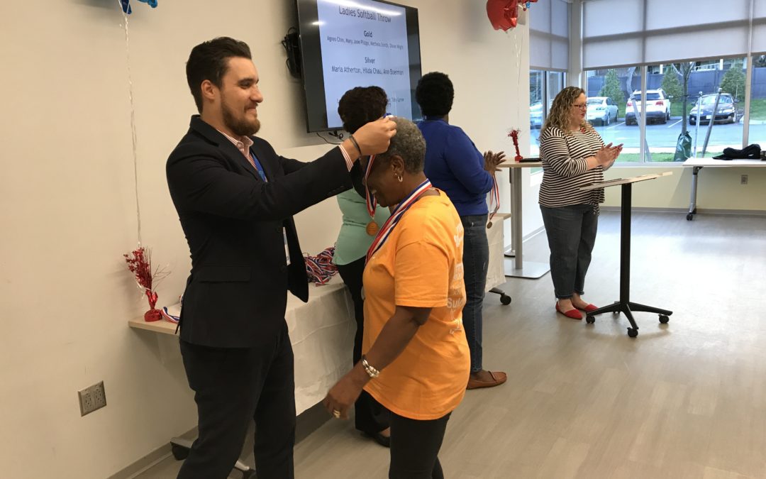 A man giving a medal to an old lady
