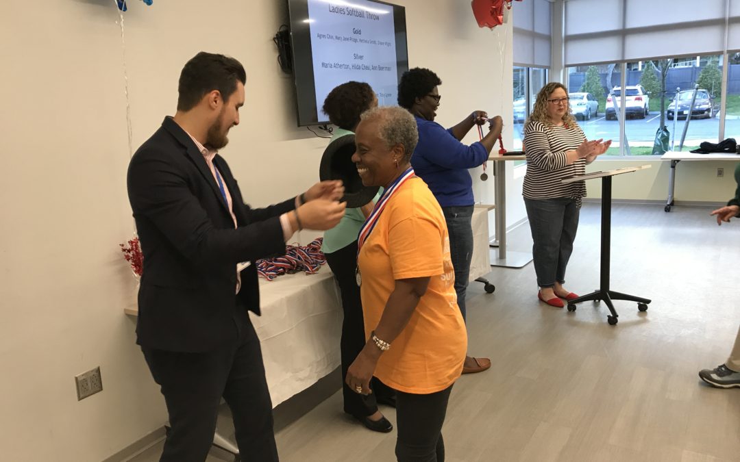 A man giving a medal to an old lady at an event