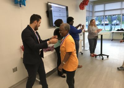 A man giving a medal to an old lady at an event