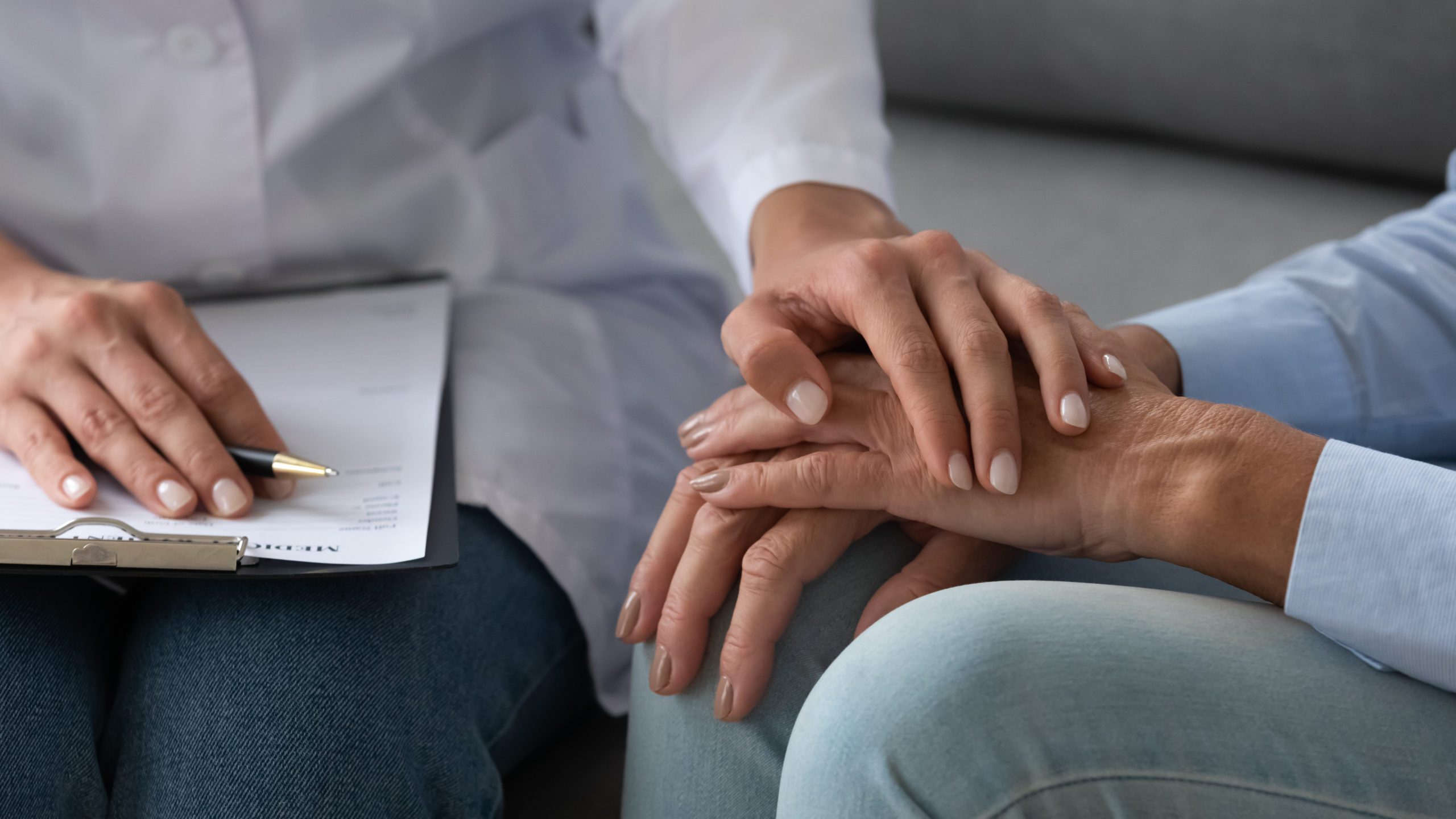 A person holding their hand over another persons arm.