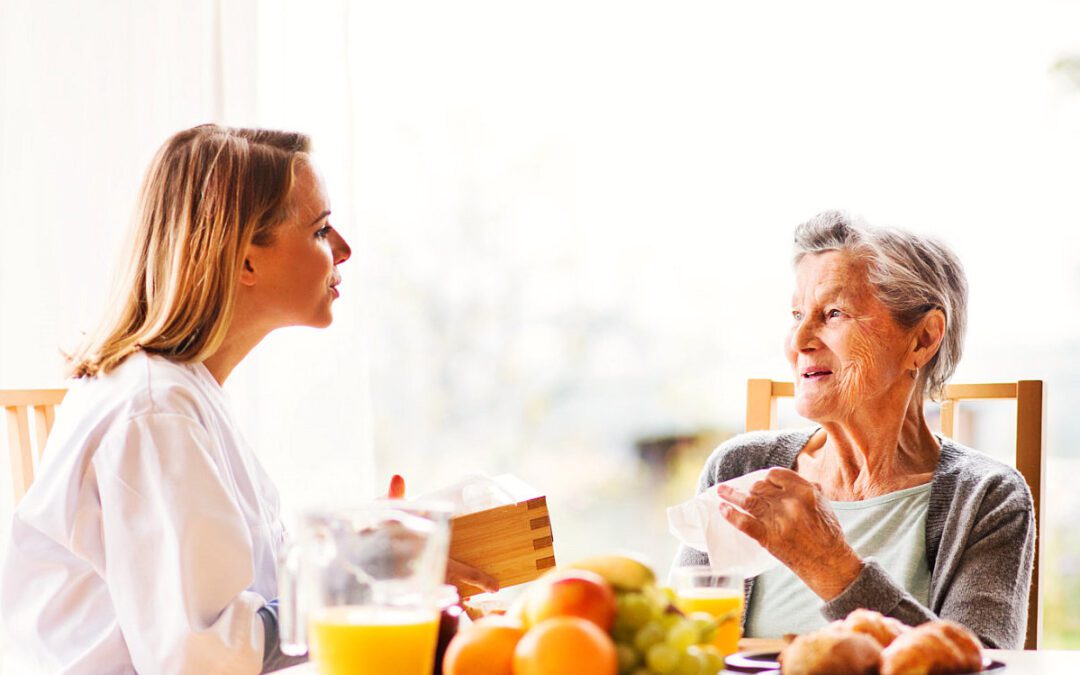 A doctor talking to an old lady while eating