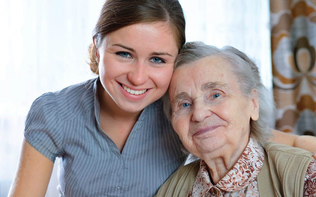 A woman and an old lady smiling for the camera.